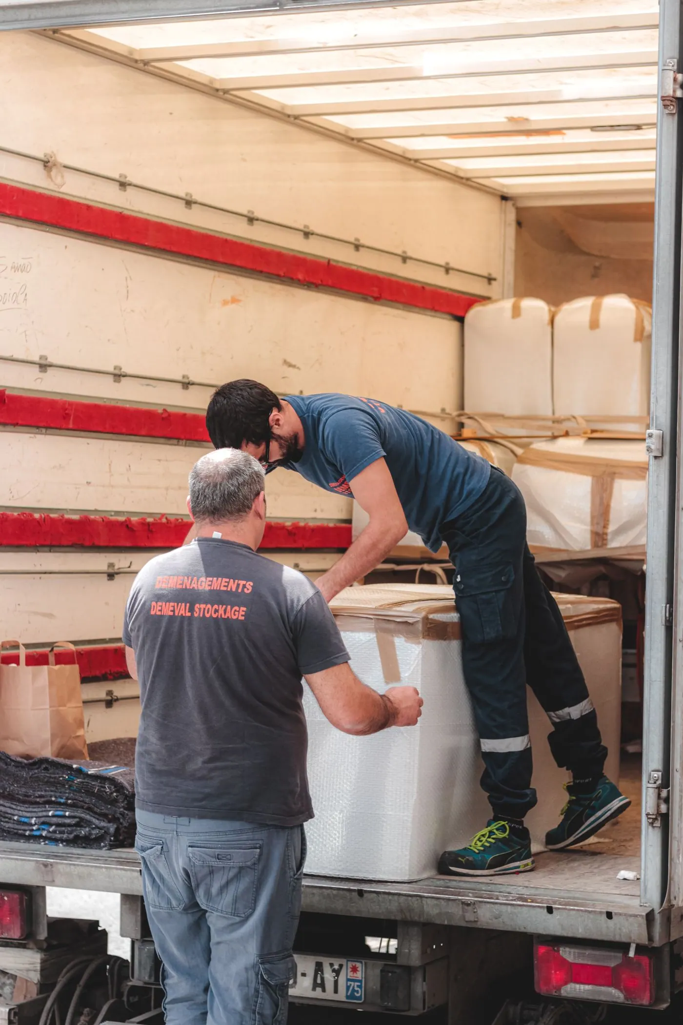 Workers unloading a consignment from the rear of a delivery truck